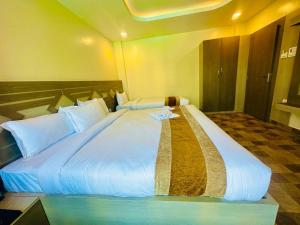 ein großes weißes Bett in einem Zimmer mit in der Unterkunft Hotel Reborn in Sanwal