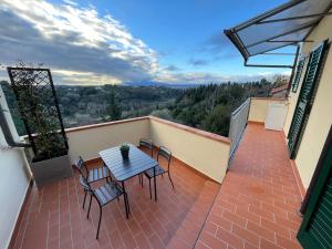 a patio with a table and chairs on a balcony at DomuS Miniato in San Miniato