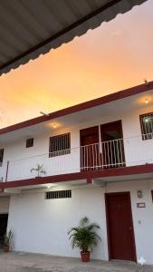 a white building with windows and a balcony at Posada Azeneth in Oxkutzcab