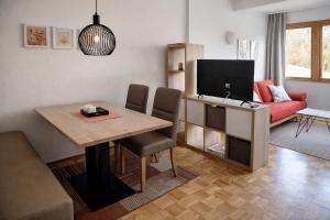 a living room with a dining room table with a television at Ferienwohnungen Vidoni in Bodensdorf