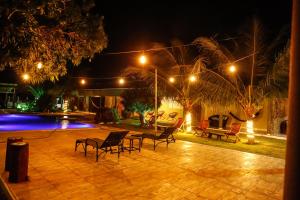 a patio with chairs and a pool at night at Pousada Du Porto in Macau