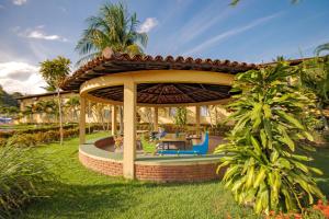 a gazebo with a table and chairs in a yard at Portobello Park Hotel in Porto Seguro