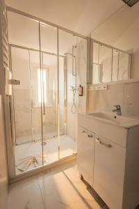 a white bathroom with a shower and a sink at Dwie Wieże in Międzyzdroje +51 photos