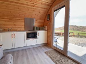 a kitchen with a sliding glass door in a cabin at Lili Wen Fach in Ruthin +19 photos