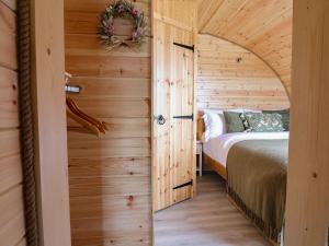 a bedroom with a bed and a wooden wall at Lili Wen Fach in Ruthin
