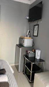 a room with a tv and a table with a microwave at Namhla Guest House in Nongoma
