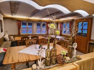 a dining room with a wooden table with vases on it at Hansenchristenhof in Gutach