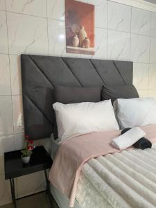 a bedroom with a bed with a gray headboard at Namhla Guest House in Nongoma +11 photos