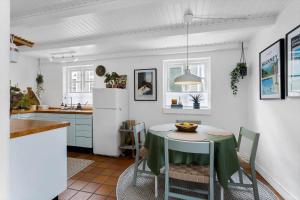 a kitchen with a table and a white refrigerator at AE318-Marstal-Faergestraede-45 in Marstal