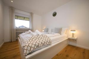 a white bed in a room with a window at Ferienwohnung MehrBlick in Garmisch-Partenkirchen