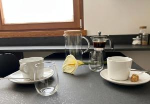 a table with cups and plates and a coffee maker at GUEST ROOM GRADONOVE in Arco