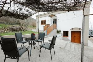 a patio with a table and chairs in front of a house at Guest house Ivan in Međugorje
