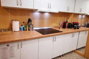 a kitchen with white cabinets and a wooden counter top at eXperience Rooms Valencia in Valencia