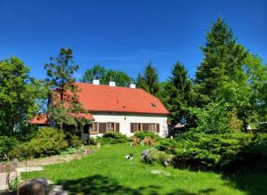 a house with a red roof in a yard at Barn - Nocleg na Mazurach in Sołtmany