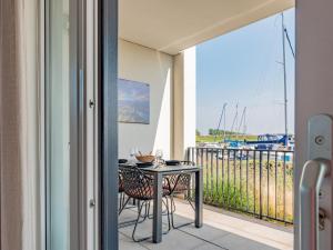 a balcony with a table and chairs and a view of a harbor at Het Havenverblijf in Kamperland