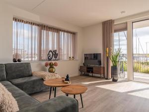 a living room with a couch and a tv at Het Havenverblijf in Kamperland