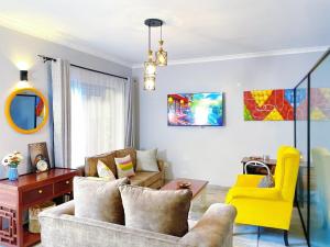 a living room with a couch and a yellow chair at Lilac cottage in Gatunga