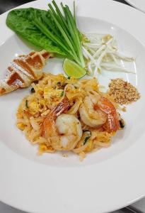 a white plate of food with shrimp and noodles at Nine Hotel Chiangmai in Chiang Mai