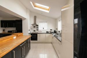 a kitchen with black and white cabinets and a sink at Contemporary Private Home Near Nottingham with Free Parking and Garden in Sandiacre