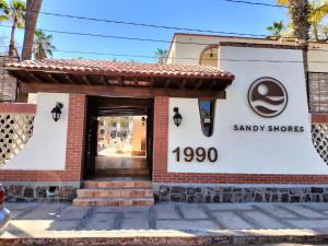 a small shop with a sign that reads sandy shops at Sandy Shores Cabaña 5 in La Paz