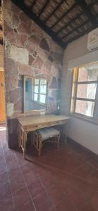 a wooden bench in a room with a stone wall at Sandy Shores Cabaña 5 in La Paz +25 photos