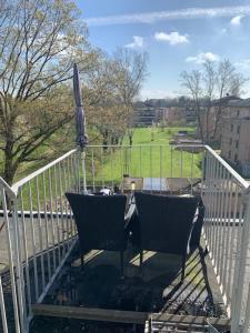 two chairs sitting on a balcony with a fence at Studio 29 in Oberhausen