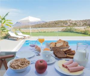 a table with a tray of breakfast food on it at Κatakis Villas in Agios Onoufrios