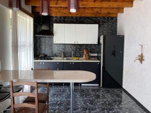 a kitchen with a table and a refrigerator at Guest House Maxim in Makhinjauri