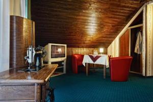 Zimmer mit einem Tisch und roten Stühlen sowie einem Zimmer mit einem Tisch in der Unterkunft Noclegi I Restauracja Zodiak in Gliwice