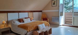 a bedroom with a bed and a large window at La Ptite Maison Gîte Alsace à la campagne in Sickert