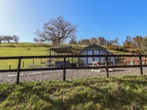 a house in a field with a fence at Cennin Pedr in Ruthin