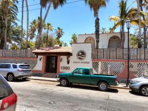 a green truck parked in front of a building at Sandy Shores Cabaña 4 in La Paz