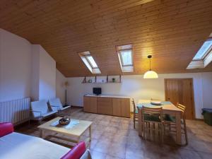 a living room with a table and a kitchen with skylights at Apartaments Vall Ferrera in Areu
