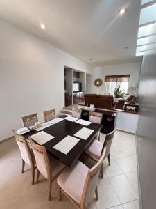 a dining room with a black table and chairs at Casa Ejecutiva Acogedora Impecable AGS in Aguascalientes