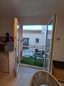 a kitchen with a balcony with a table and chairs at Locmeze in Mèze