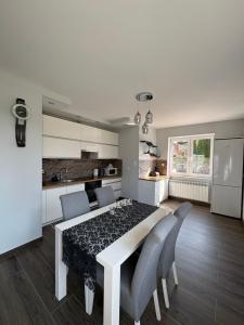 a kitchen and dining room with a table and chairs at Biebrzańska Dolina 1 in Goniadz