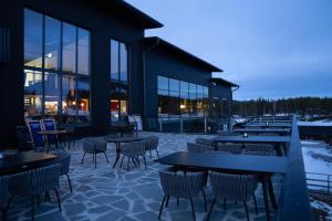 a patio with tables and chairs in front of a building at Hotelli Suomutunturi in Suomutunturi