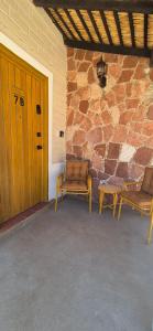 two chairs and a table in front of a stone wall at Sandy Shores Cabaña 7 in La Paz