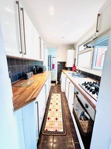 a kitchen with white cabinets and a checkerboard floor at Reading Central Haven in Reading
