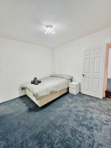 a white bedroom with a bed and a ceiling fan at Reading Central Haven in Reading +3 photos