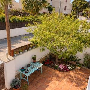 a small garden with a bench and potted plants at Piscina privada de Sal, Cala Canyadell in Torredembarra