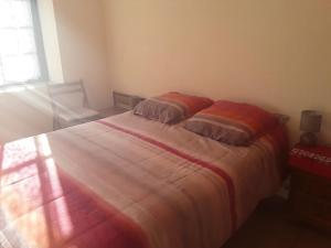 a bedroom with a bed with two pillows on it at Maison au tilleul in Ribiers