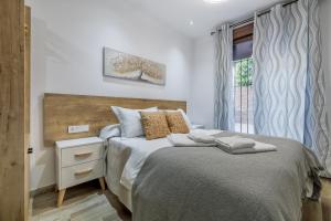 a bedroom with two beds and a window at Apartamentos Toril in Córdoba