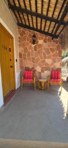 two red chairs and a table on a patio at Sandy Shores Cabaña 10 in La Paz +35 photos