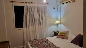 a bedroom with a bed and a window at Calidez & Luz Rosario in Rosario