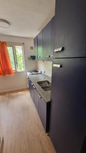 a kitchen with a black refrigerator and a wooden floor at Calidez & Luz Rosario in Rosario
