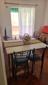 a table and chairs in a room with a window at Calidez & Luz Rosario in Rosario