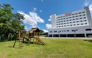 a playground in front of a large building at Alegro Hotel in Jarinu