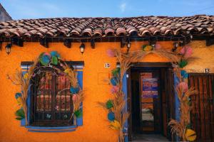an orange building with a window and a tile roof at Casa Josvic in San Cristóbal de Las Casas