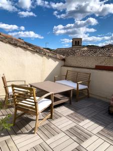 a patio with a table and chairs on a roof at Les Toits d'Aniane in Aniane